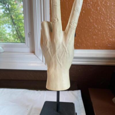 Peace sign hand sculpture on stand