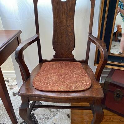 Antique Tiger Oak armchair with claw feet in front