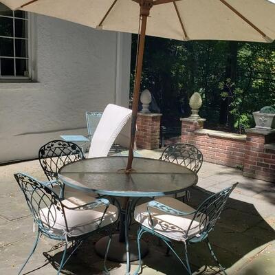 Wrought iron table, four chairs, umbrella
