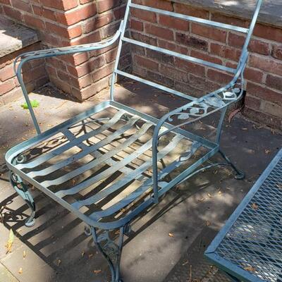 Two wrought iron chairs, footstool and table
