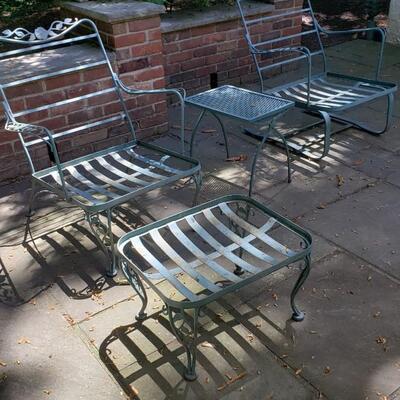 Two wrought iron chairs, footstool and table