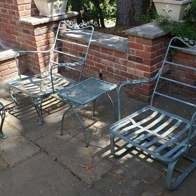 Two wrought iron chairs, footstool and table