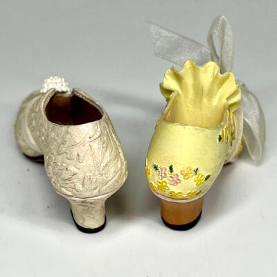 Lot of two white and yellow miniature shoe figurines
