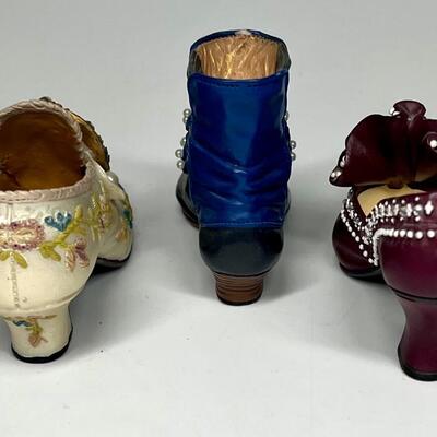 Lot of three white blue and purple miniature shoe figurines