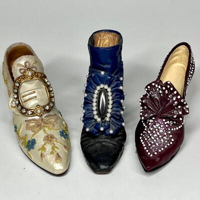 Lot of three white blue and purple miniature shoe figurines