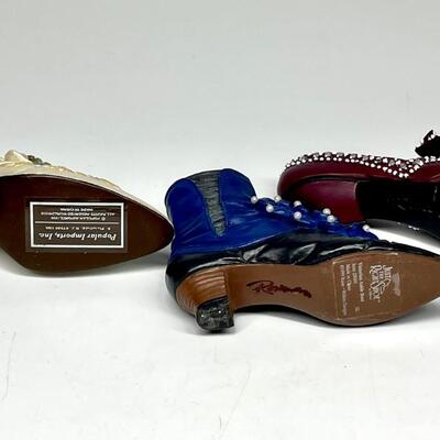 Lot of three white blue and purple miniature shoe figurines