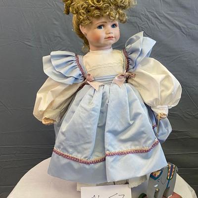Porcelain Doll With Blue Dress and Elephant Toy