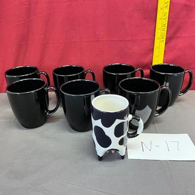 7 black and one cow mug