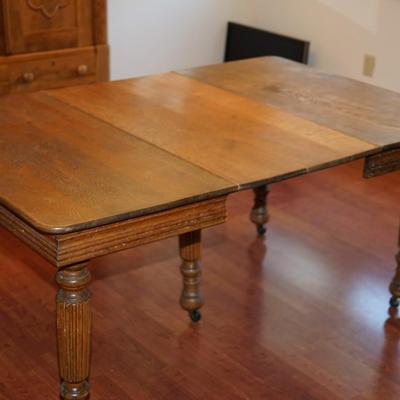 EARLY 1900'S SQUARE  OAK TABLE W/TWO LEAVES/FLUTED LEGS/ CENTER LEG SUPPORT