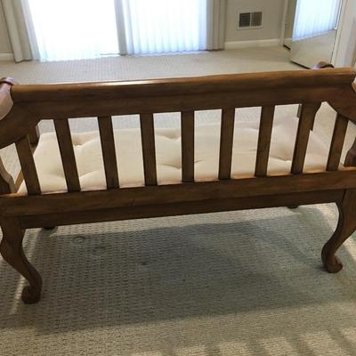 Carved wood bench with upholstered seat