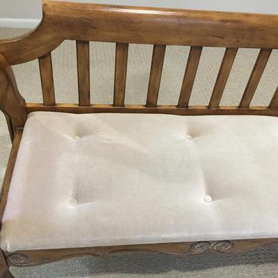 Carved wood bench with upholstered seat