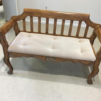 Carved wood bench with upholstered seat