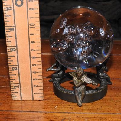 Crystal ball sitting on a stand of cherubs