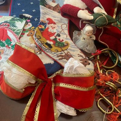 2 needlepoint stockings, bows, ribbon, brass horns, Santa