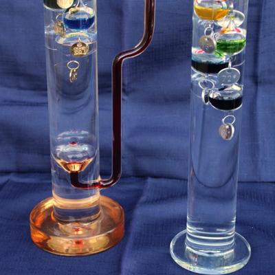 Set of 2 Galileo thermometers (20" and 14"); multi-colored spheres. Some water evaporation.