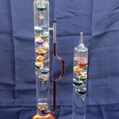 Set of 2 Galileo thermometers (20" and 14"); multi-colored spheres. Some water evaporation.
