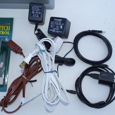 Paper shredder, assorted electrical cords, chargers, phones, and electric cables.