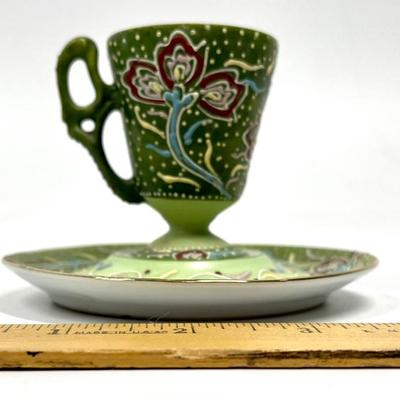 Green painted pattern tea cup and saucer