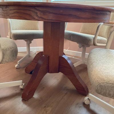 Round wood table with. 4 roller chairs