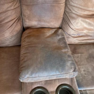 Suede brown love seat with recliners on the ends.