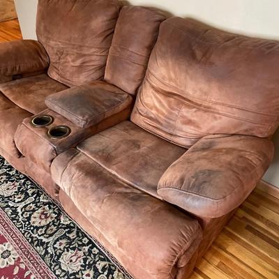 Suede brown love seat with recliners on the ends.