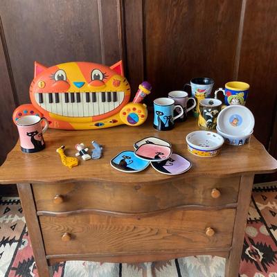 Grouping of cat themed items including a child keyboard type game and assortment of mugs and plates