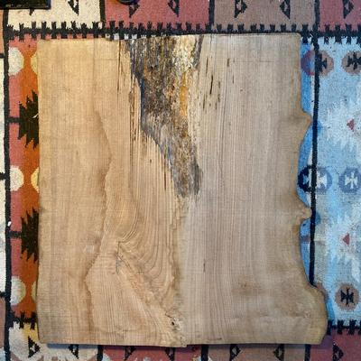 Slab of wood, live edge on one edge, finished on one side