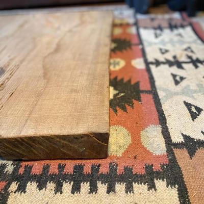 Slab of wood, live edge on one edge, finished on one side