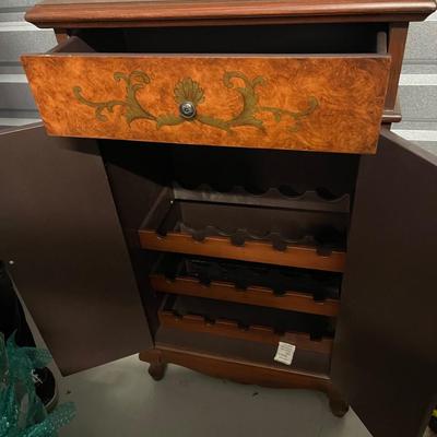 Vintage wine cabinet. Has storage shelf on top of inside of cabinet and wine racks for wine bottles. One handle is off. It it can be...