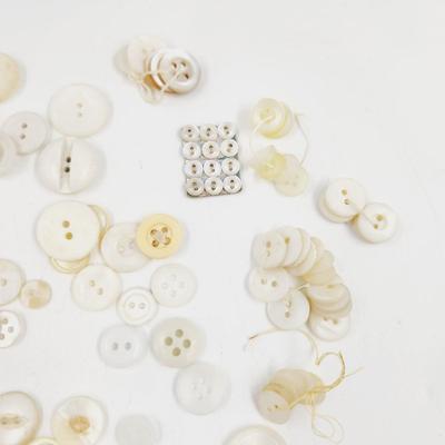 VINTAGE PILE OF MULTI TONED WHITE BUTTONS