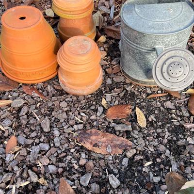 4 terracotta planters and a watering can