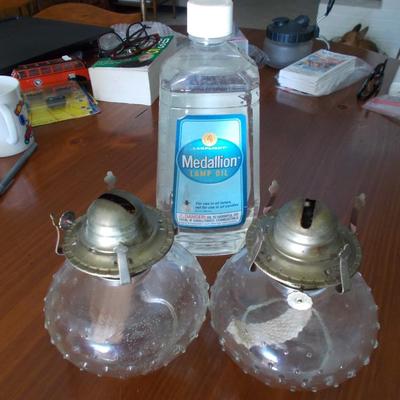 Two vintage bubble glass oil lamp bases and a bottle of lamp oil