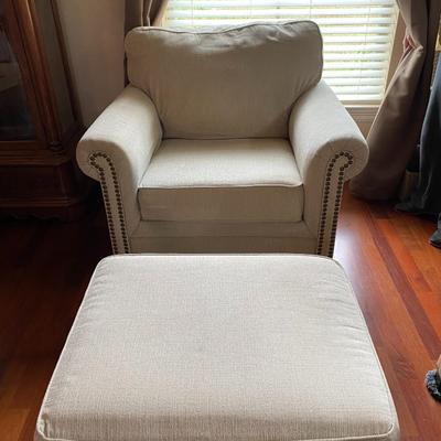 Fabric cream-colored upholstered chair with ottoman