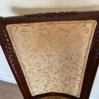 Beige upholstered ornately carved wooden chair