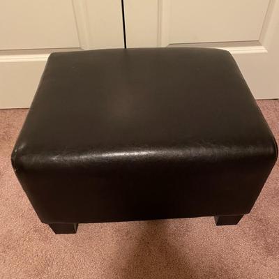 Black faux leather footed ottoman