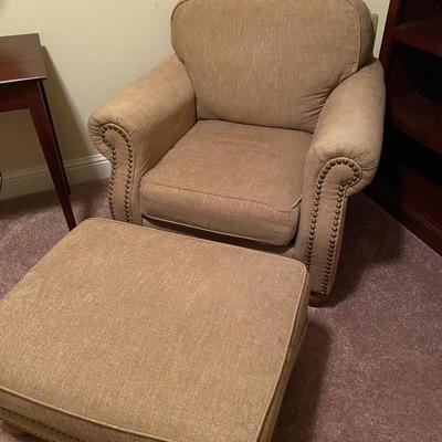 Upholstered tan nail-head chair with ottoman