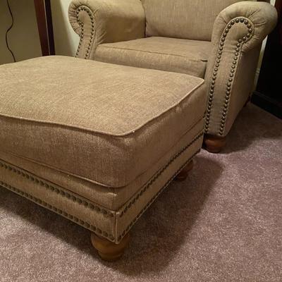 Upholstered tan nail-head chair with ottoman