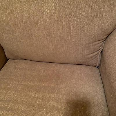 Upholstered tan nail-head chair with ottoman