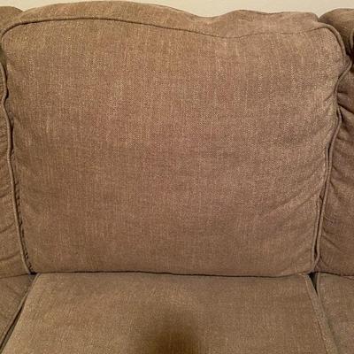 Tan upholstered sofa with nail-head trim