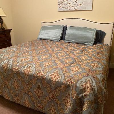 King-size bed with off-white upholstered nail-head headboard
