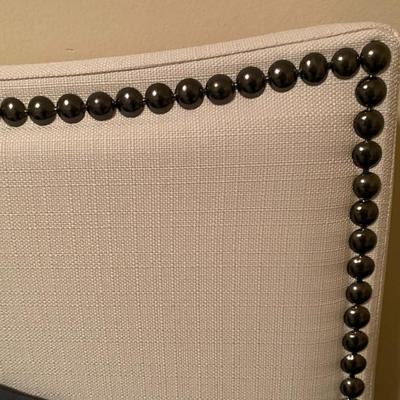 King-size bed with off-white upholstered nail-head headboard