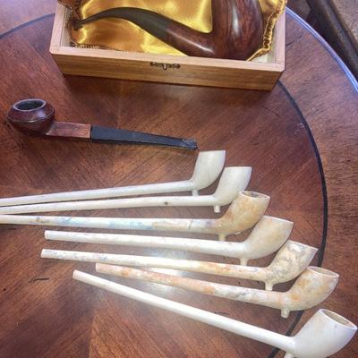 Lot of smoking pipes with two wooden pipe stands