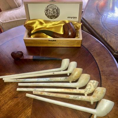 Lot of smoking pipes with two wooden pipe stands