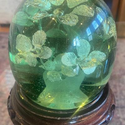 Vintage Green Glass paperweight with silver flowers suspended inside on carved wood stand