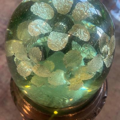 Vintage Green Glass paperweight with silver flowers suspended inside on carved wood stand