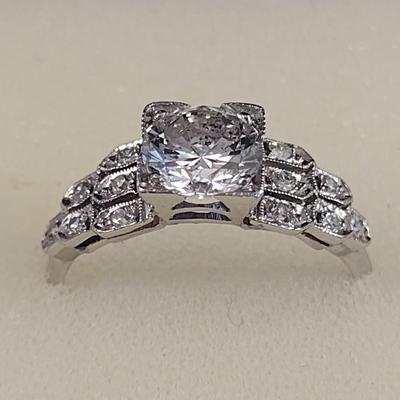 Platinum Diamond Ring with Center 1.12 Carat Diamond and One Dozen Diamond Chips Set in Sheild Design Band