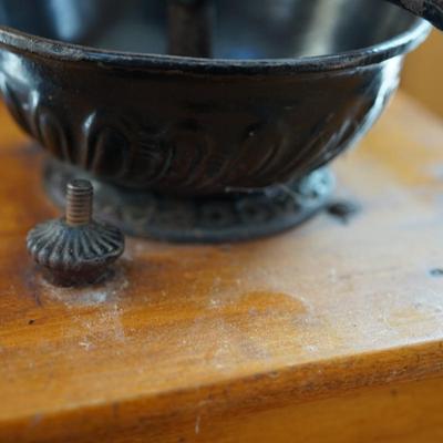 ANTIQUE CRANK TABLE TOP COFFEE GRINDER W/ CAST IRON CRANK/ PRESSED DESIGN ON THE BEAN COMPARTMENT.