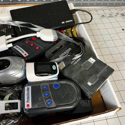 Tray of Electrical things; Cables, juice pack, garage Door openers, Alarms