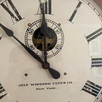 Self-winding clock. Large brass pendulum. 63â€ high, 19â€ wide, 7â€ deep.