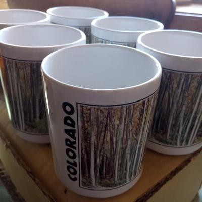 NEW COLORADO COFFEE MUGS, COLORADO POSTCARDS AND PENNIES IN A GLASS BOTTLE